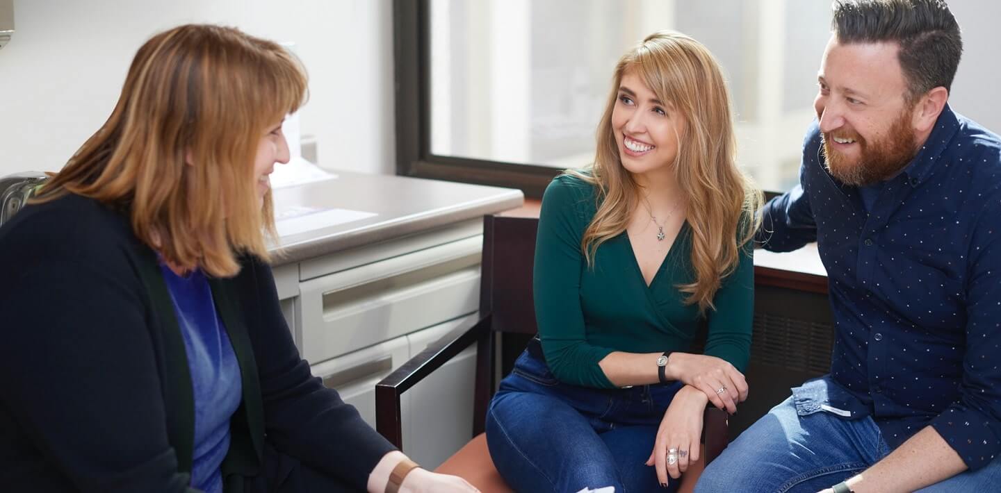 A fertility specialist speaking to a man and a woman