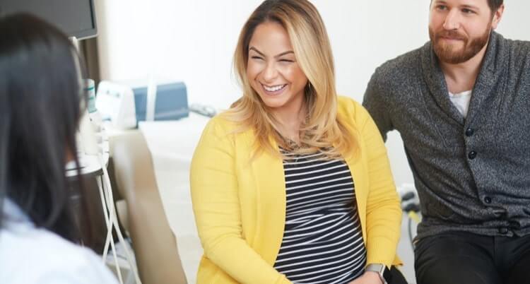 A doctor speaking to a couple about medical care