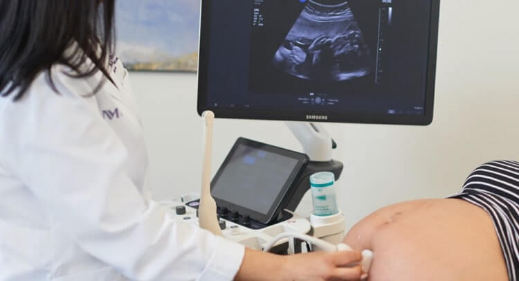 A technician performing an ultrasound on a pregnant woman